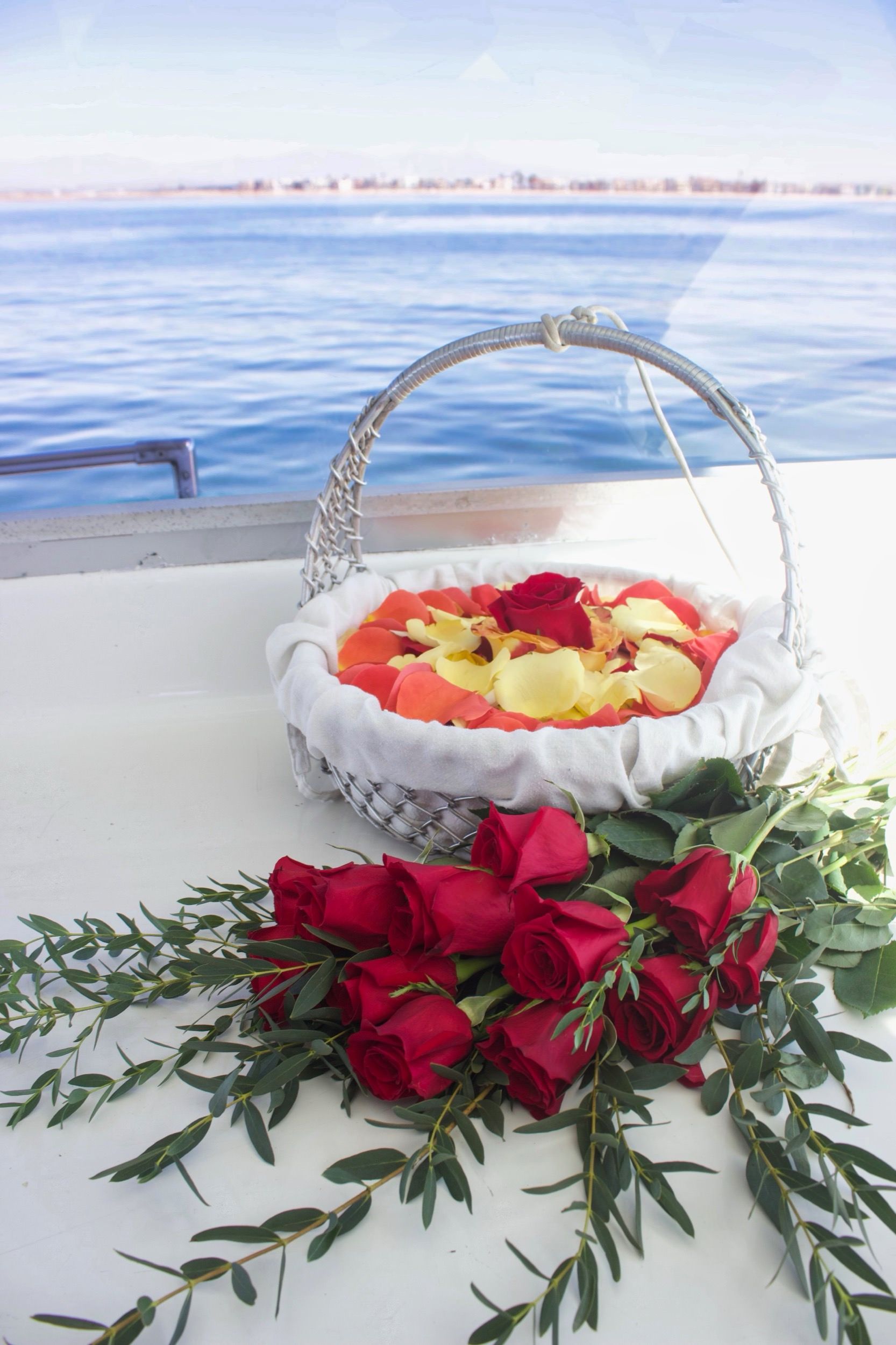 A cloth-lined basket of rose petals aboard the boat, prepared for a scattering at sea