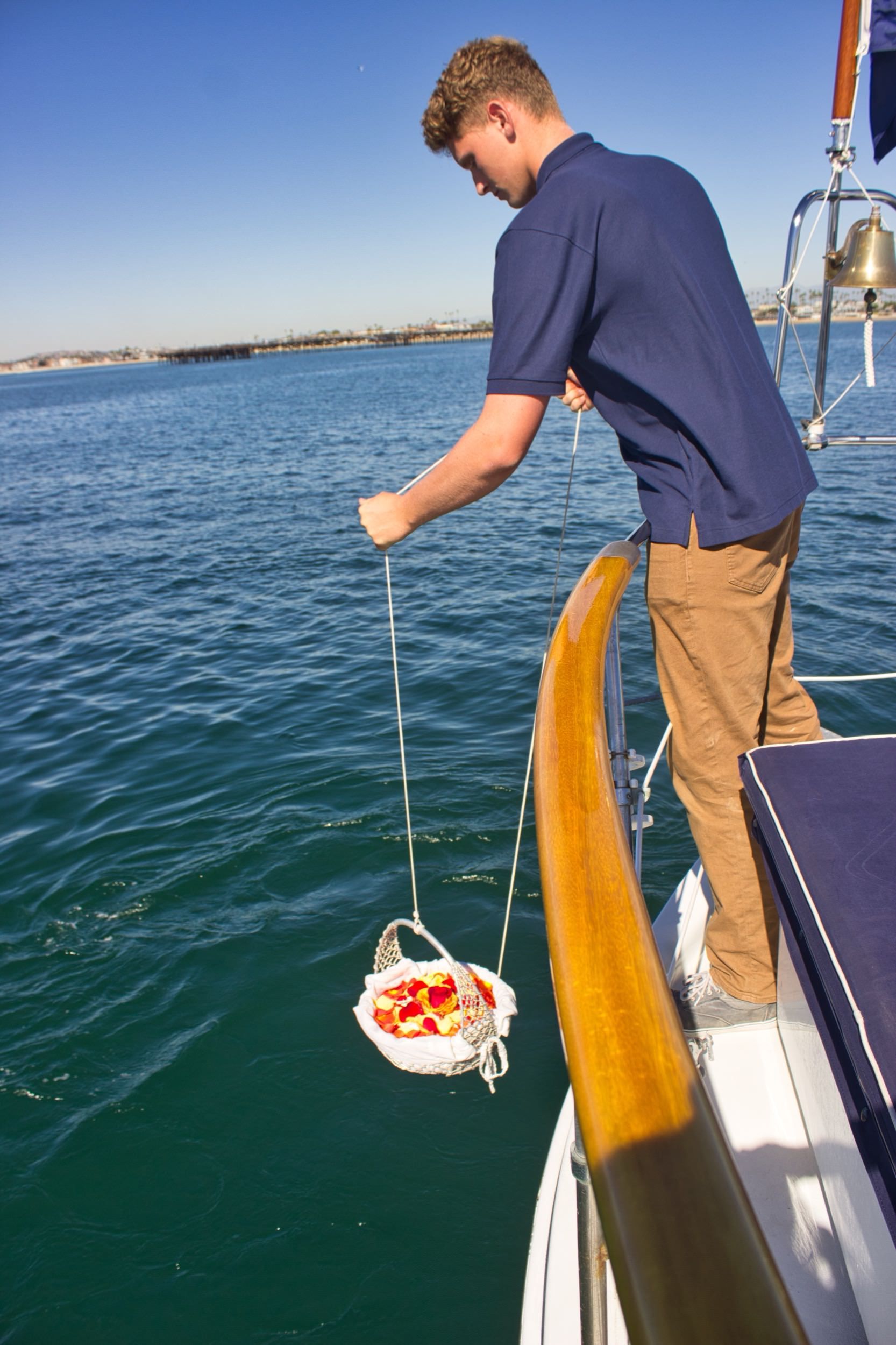 Lowering ashes into the water during a scattering service